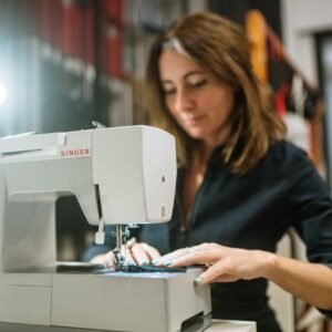 Mujer cosiendo en máquina de coser Singer girs