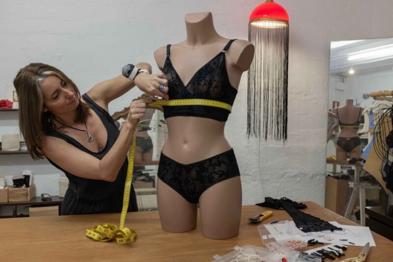 Mujer tomando medidas con cinta métrica en maniqui