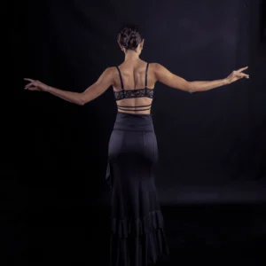 Mujer bailando flamenco en sujetador de encaje y falda negra