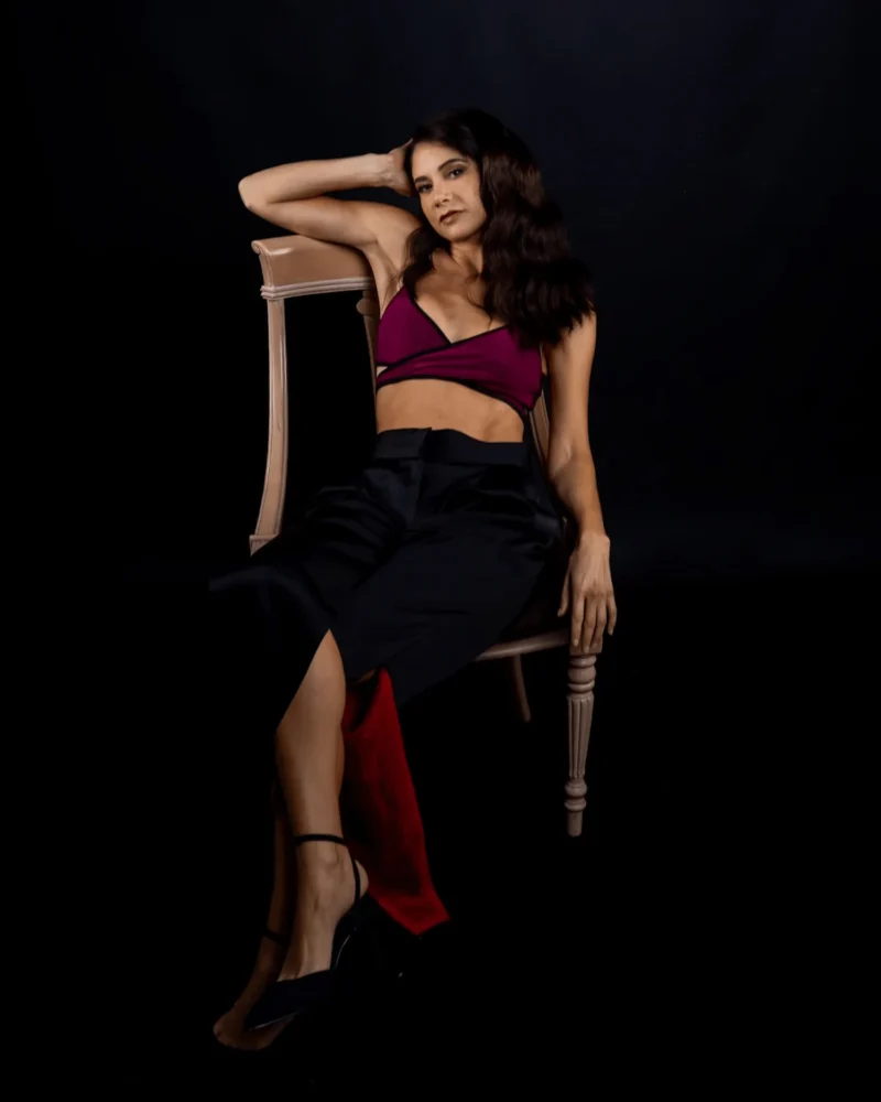 Mujer sentada en una silla con top y pantalon