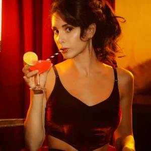 mujer bebiendo cocktail, usando top de terciopelo suave. Hecho a mano en Barcelona